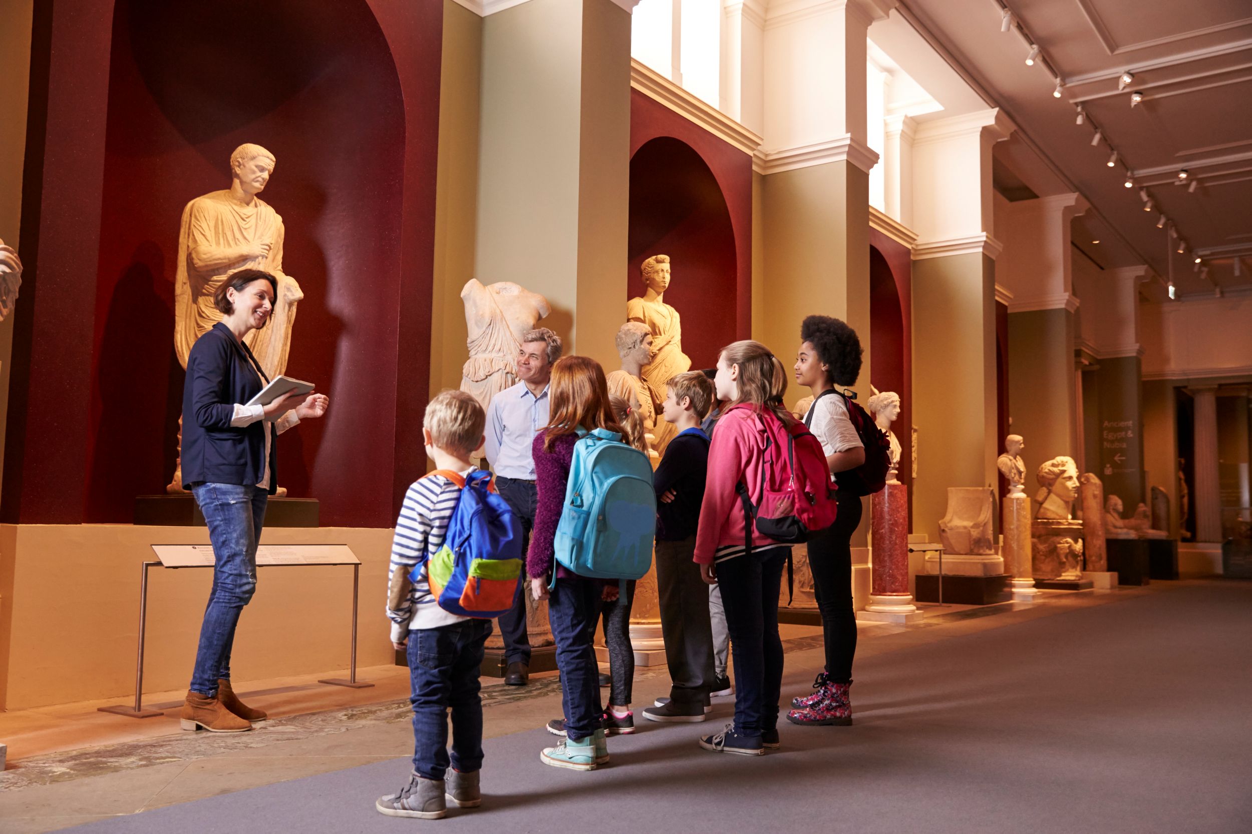 Pupils with a teacher in a museum on a guided tour