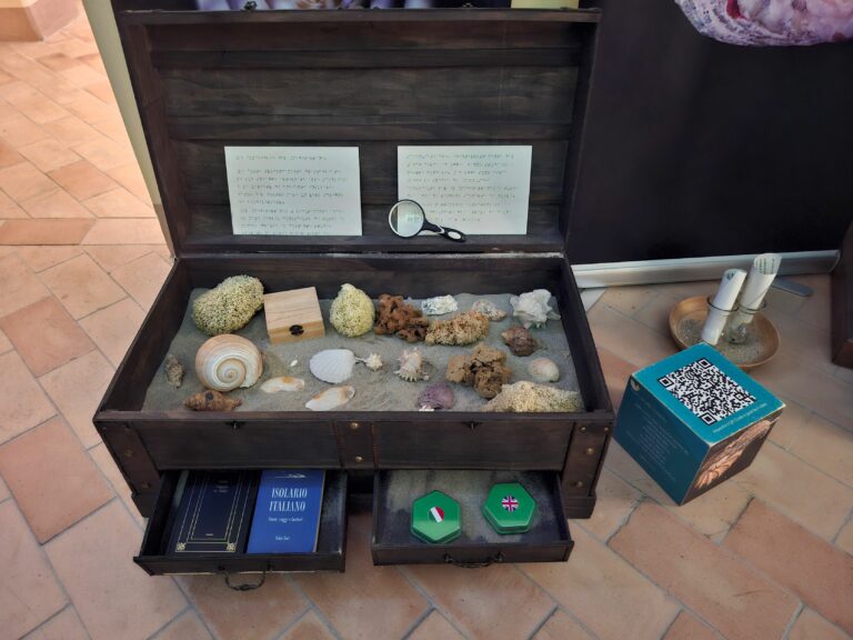 Nel Museo di Malakos si trova una cassa sensoriale contenente conchiglie, sabbia, audio, testi e informazioni in Braille