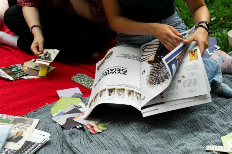 A person cutting out something from a magasine.