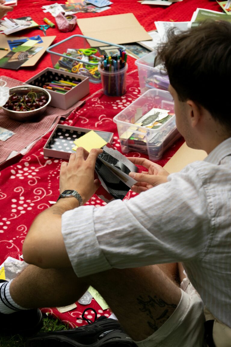 A person cutting out with scissors materials for their zin.